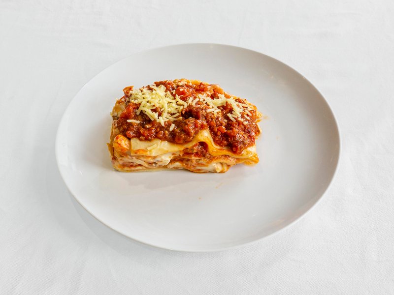 A slice of homemade lasagne, layered with bolognese and topped with melted cheese